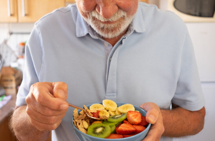 Senior man ready to eat a salad of fresh and dried fruits. Break Your Protein Timing Is Wrong