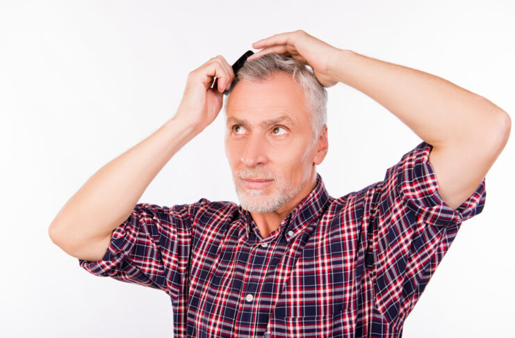 Confident gray aged man combing hair Your Hair Started Thinning Years Ago