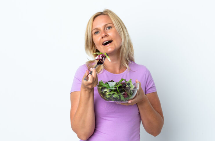 Middle age Lithuanian woman isolated on white background holding a bowl of salad with happy expression Always Hungry After Salads